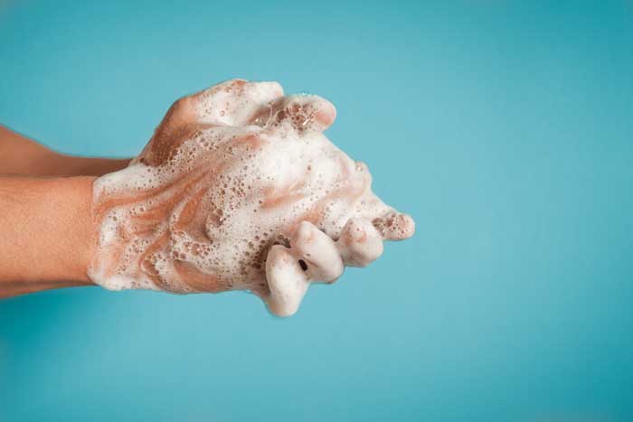 close-up of a person washing their hands with soap and water