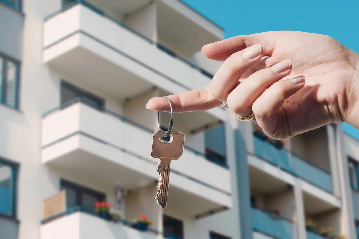 A woman holds a key in front of a vacation property