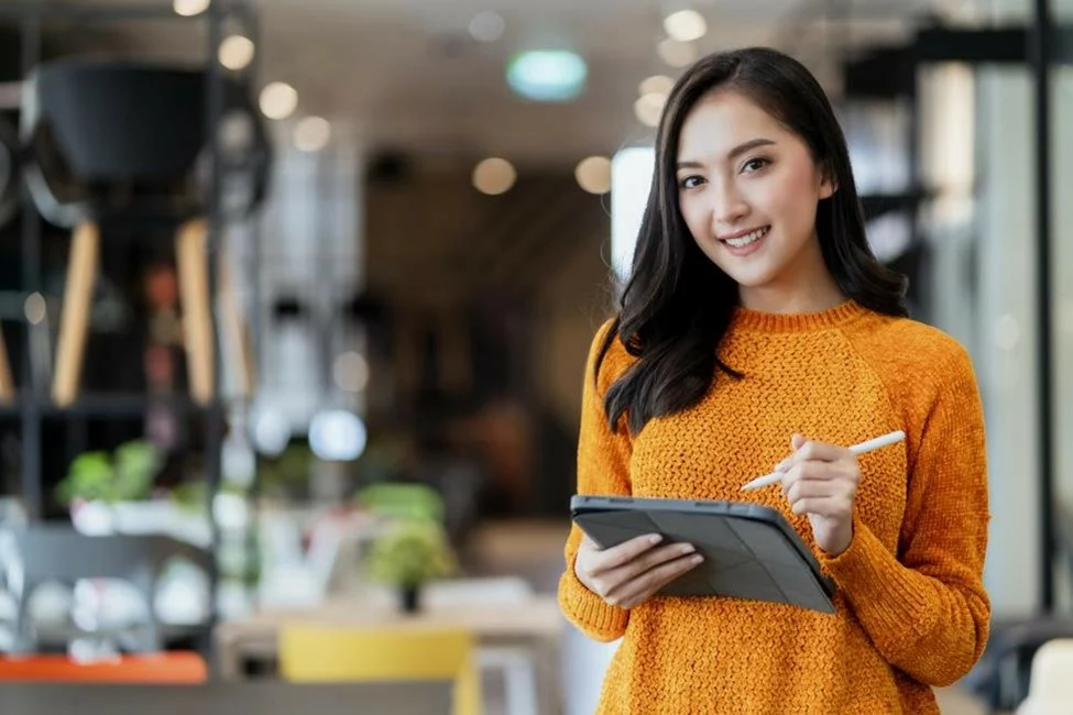 Young entrepreneur with tablet in hand standing in front of inventory.