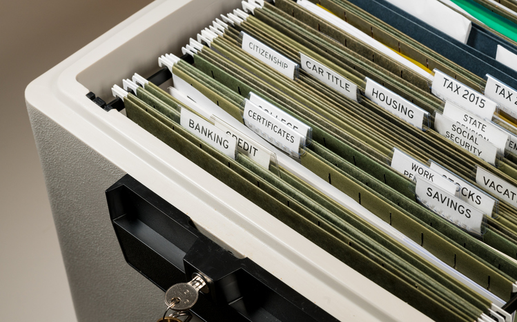 An organized filing cabinet with labeled folders full of documents.