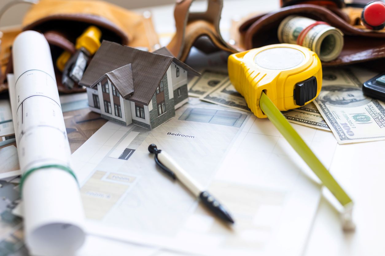 A model house on blueprints with keys to the new home for upcoming spring renovations.