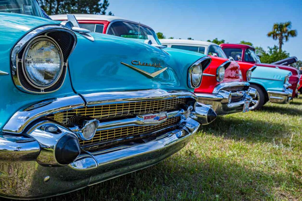 Classic Chevrolets parked in a row on the grass at a car show.