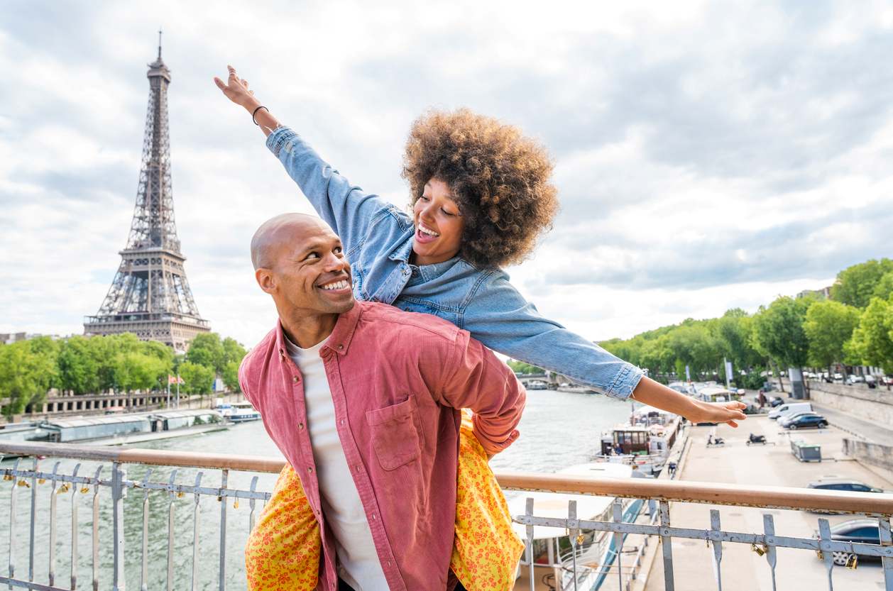 A happy couple dances together while living abroad in Paris.