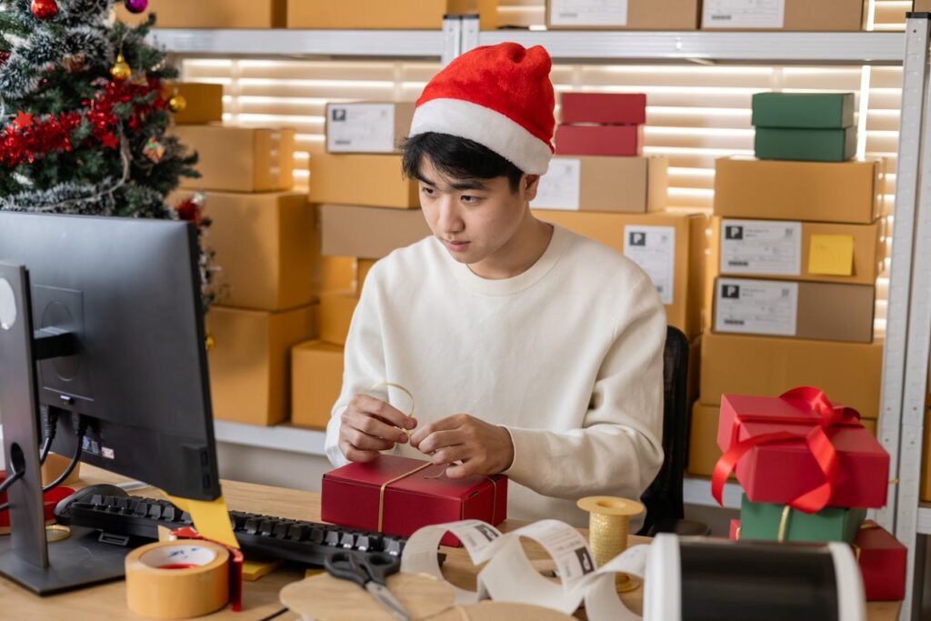 A man wrapping holiday packages in his office